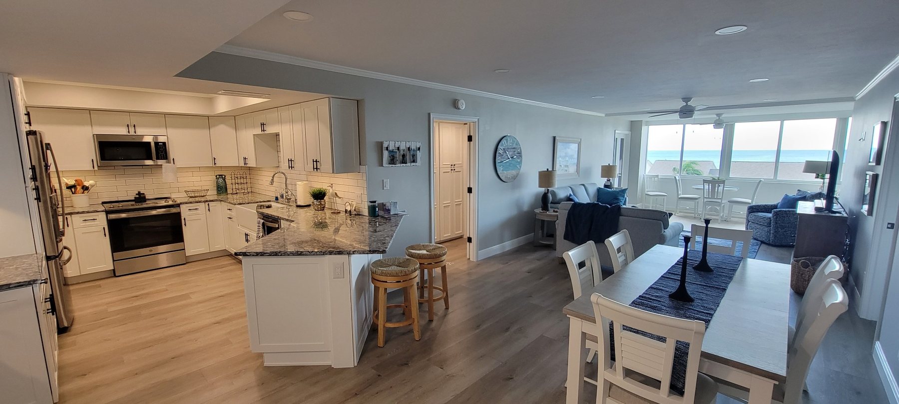Completed coastal whole-home renovation with open kitchen, dining and waterfront living space