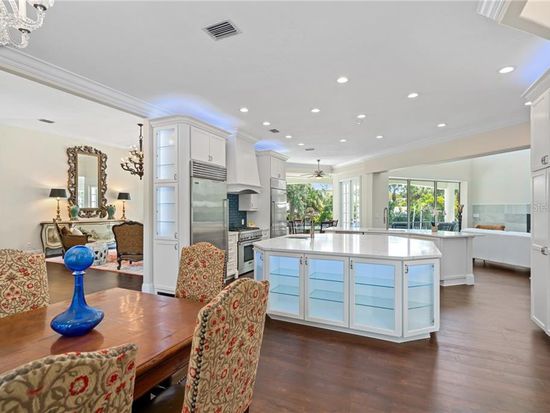 Wide view of completed open-concept white kitchen from dining area