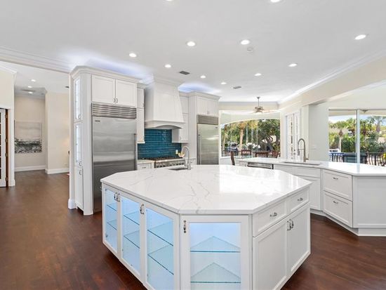 Completed white kitchen showing island and stainless appliances