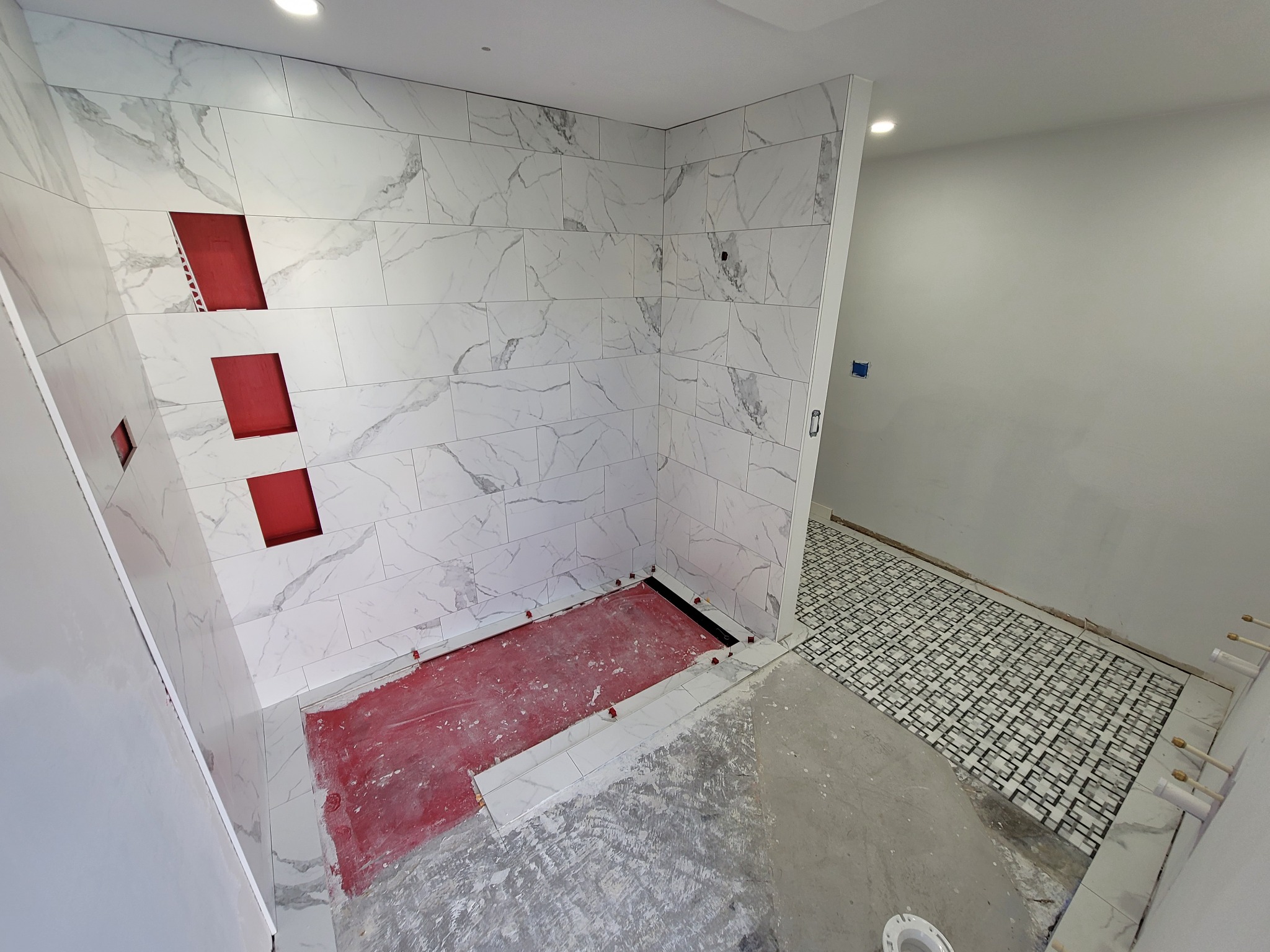 Shower tile and mosaic floor installation in progress